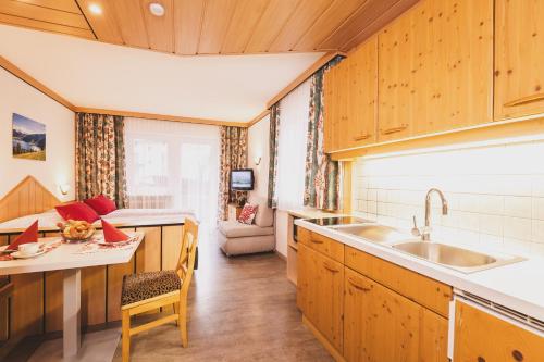 a kitchen with wooden cabinets and a sink at Haus Voglreiter - inkl Sommerkarte, zentrale und ruhige Lage, Garten mit Spielplatz in Kaprun