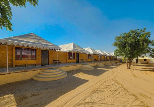 a row of buildings on a dirt road at Quba Desert Camp Jaisalmer in Jaisalmer