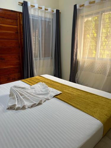 a bedroom with a bed and a window with curtains at The Wink apartments in Malindi