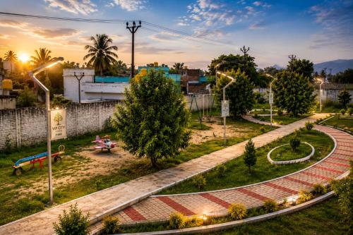a park with a bench and trees and lights at CG Blue Horizon Villa in Vellore
