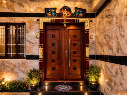 a front door of a house with plants and lights at CG Blue Horizon Villa in Vellore