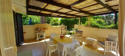 a patio with a table and chairs under a pergola at Maison Laujo en bord de mer in Santa-Maria-Poggio