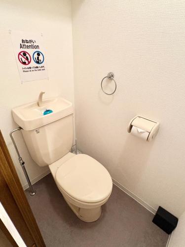 a bathroom with a toilet and a sign on the wall at Stay min NAKAMURA in Nagoya