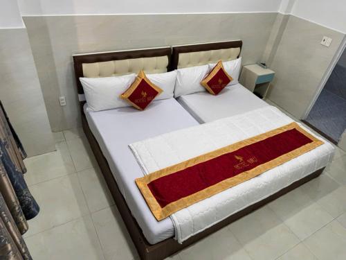 a bed with two pillows and a blanket on it at Hotel Bros in Ho Chi Minh City