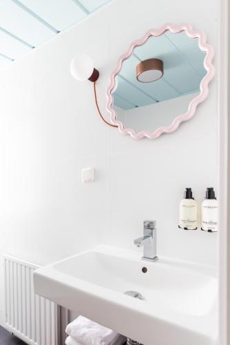 a bathroom with a sink and a mirror on the wall at Hotel Domburg4you in Domburg