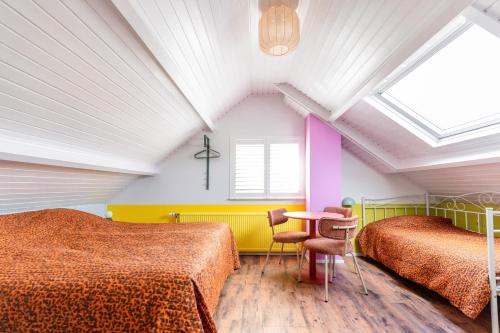 a room with two beds and a table in it at Hotel Domburg4you in Domburg