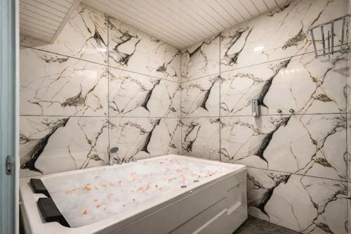 a bathroom with a white and black marble wall at Hotel Rism Suites Koramangala in Bangalore