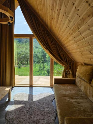 a room with a couch and a large window at Кольсай Тау Оректы resort in Kurmenty