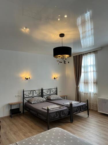 a bedroom with a bed and a chandelier at Casa Bianca Kobuleti in Kobuleti