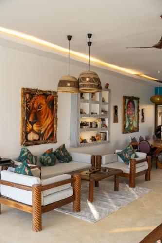a living room with couches and tables and paintings at beacfront villa claudius ,michamvi in Michamvi