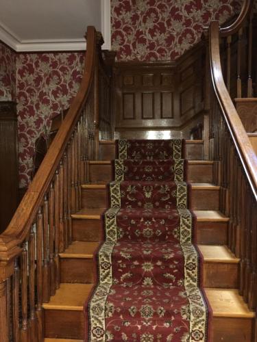 a staircase in a house with a red carpet at Fenway Park Brownstone in Boston
