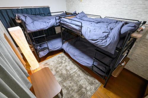 two bunk beds in a room with a table at soleggiato suminoe in Osaka