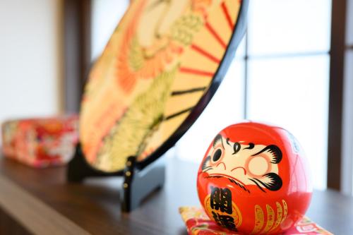 a toy clown sitting on a table next to a suitcase at soleggiato suminoe in Osaka