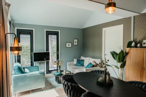 a living room with a table and a couch at Knus I Tiny house op de Veluwe in Epe