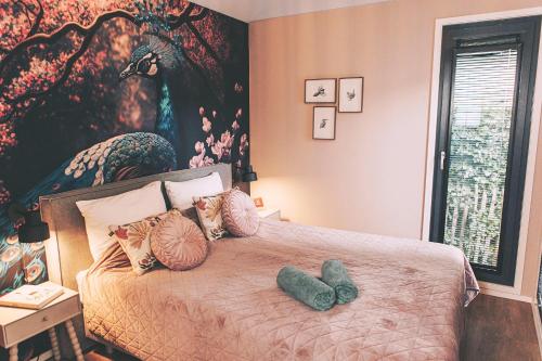 a bedroom with a bed with two stuffed animals on it at Knus I Tiny house op de Veluwe in Epe