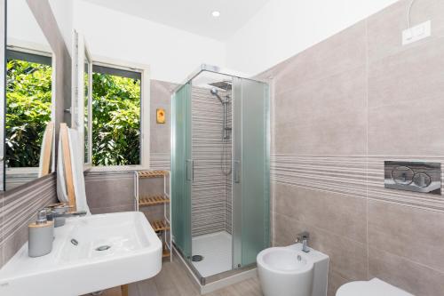 a bathroom with a shower and a sink and a toilet at Tropical House in San Leonardello