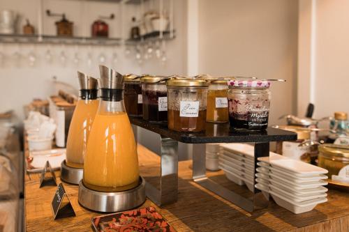 a shelf with jars of honey and orange juice at Hôtel Spa - Au Charme Rabelaisien in Amboise