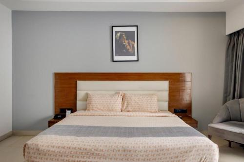 a bedroom with a large bed and a chair at asar Upper House Morjim Beach by Orion Hotels in Morjim