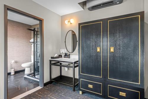 a bathroom with a toilet and a sink and a mirror at Beacon Suites Hotel in Somerville
