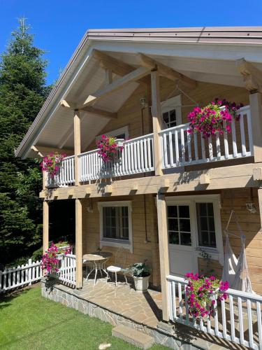 a house with flower boxes on the balcony at Tre Bujtinat Gjinar in Elbasan