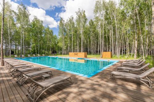 a pool with chaise lounge chairs on a wooden deck at Mandra Petrichor in Zabuyanʼye