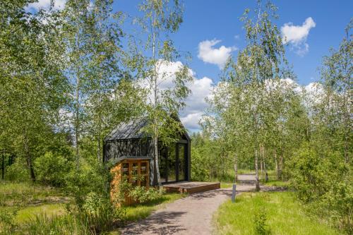 a small cabin in a forest with a dirt road at Mandra Petrichor in Zabuyanʼye