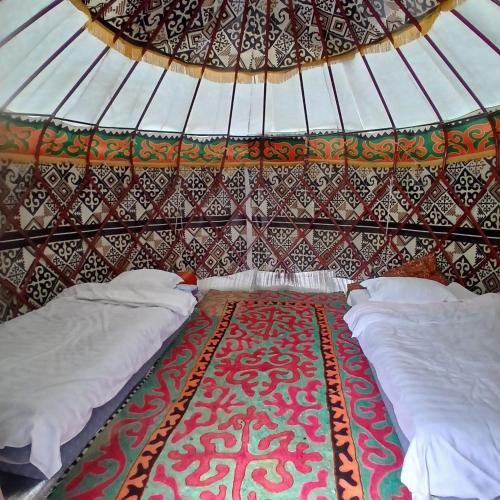 a room with two beds in a yurt at Kapchygai Yurt Camp in Dzhetyoguz