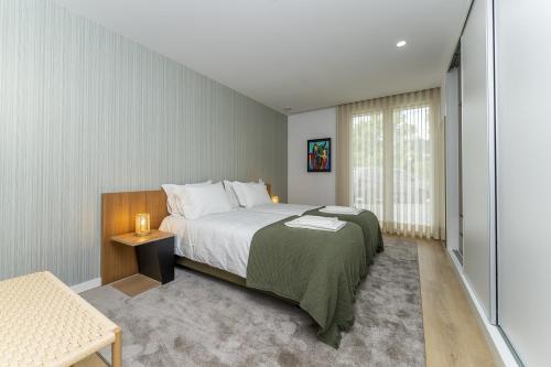 a bedroom with a large bed and a window at Refugio Moderno as Portas do Geres in Ponte da Barca
