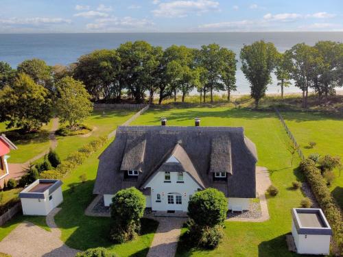 an aerial view of a white house with a roof at Reethus am Strand - Haushälfte 1 mit Kamin, Sauna in Lobbe