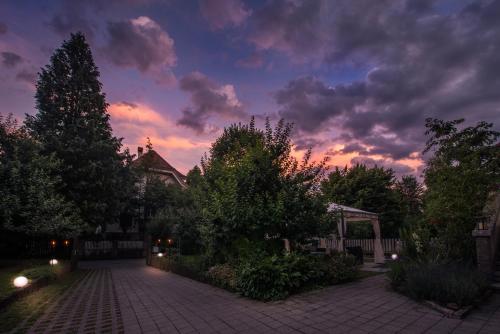 a sunset over a brick walkway in a yard at Max Aviation Villa & Apartments in Bern