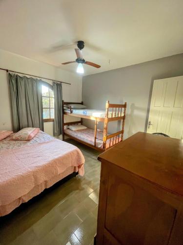 a bedroom with a bed and a ceiling fan at Casarão entre Cabo Frio e Búzios Piscina Privativa Ar condicionado, Sinuca, Totó, Churrasqueira 4 quartos Wi-Fi 500mb in Cabo Frio