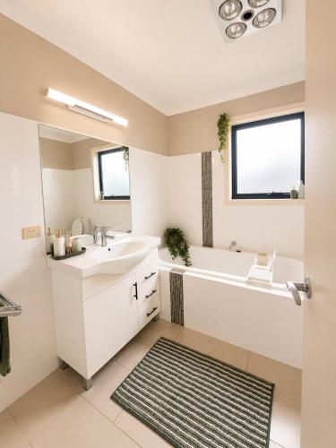a bathroom with a tub and a sink and a bath tub at The Cozy Corner Retreat in Port Sorell