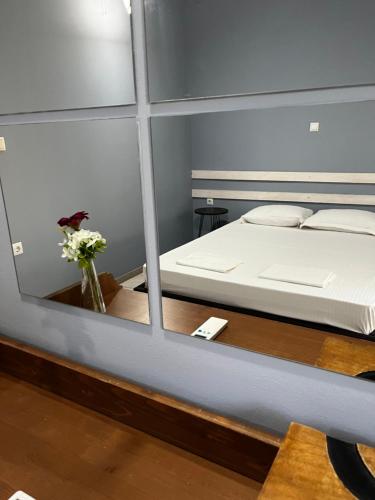 a bedroom with a bed and a vase of flowers on a table at Vicente Apartment in Skala Rachoniou