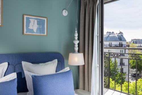 a bedroom with a bed and a large window at Hôtel Marais Hôme in Paris