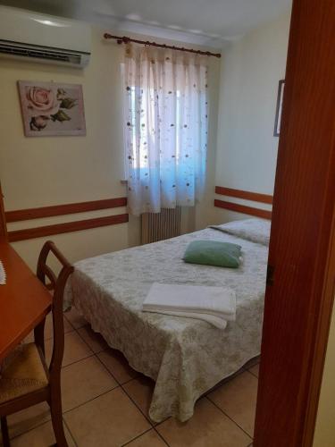 a bedroom with a bed with a green pillow on it at Gelindo Dei Magredi in Vivaro