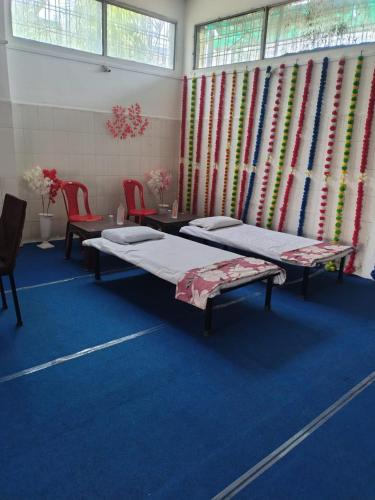 a room with two beds and a table and chairs at Hotel madhav regency bhopal in Misrod