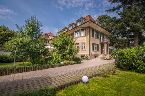 una casa grande con una entrada de ladrillo delante de ella en Max Aviation Villa & Apartments, en Berna