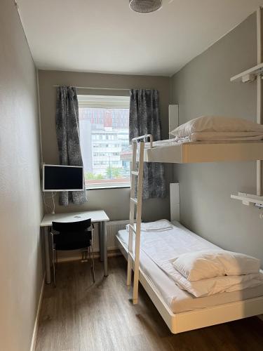 a dorm room with a bunk bed and a desk at Bodo Motel Norway in Bodø