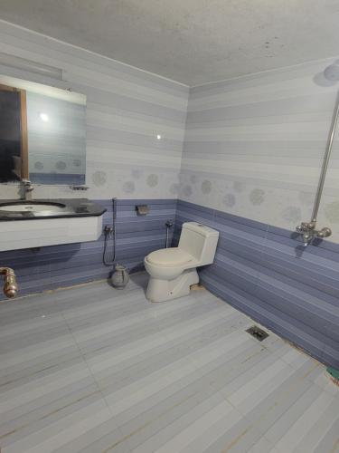 a bathroom with a toilet and a sink at INTOWN Hotel in Islamabad