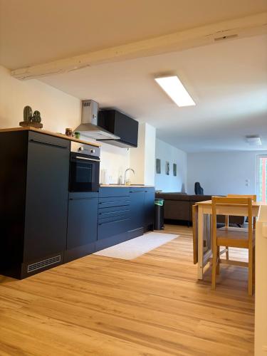 a kitchen with blue cabinets and a table in a room at Modern Apartment 2 Graf - New!! in Grafenwöhr