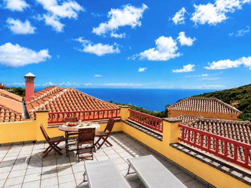 a balcony with a table and chairs and the ocean at Emiliana in Puntallana