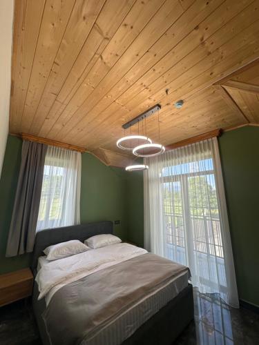 a bedroom with a large bed and two windows at Royal Forest Dilijan in Dilijan
