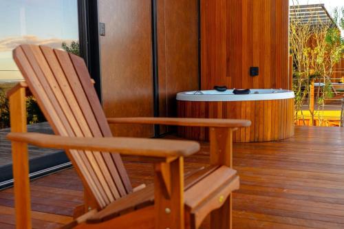 a pair of wooden chairs sitting on a porch at Refúgio Tapera Bungalows & Wellness in Venda Nova do Imigrante