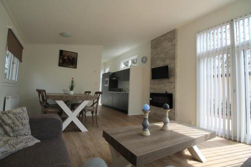 a living room with a table and a dining room at Residence de Eese in De Bult