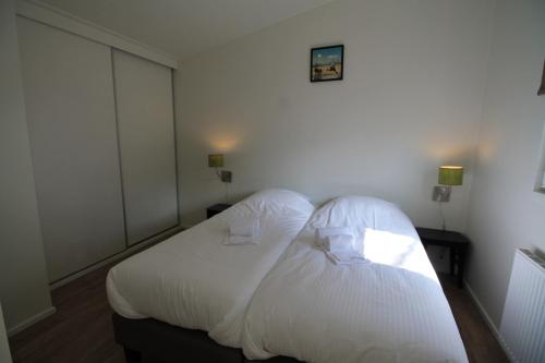 a bedroom with a white bed with two pillows at Residence de Eese in De Bult