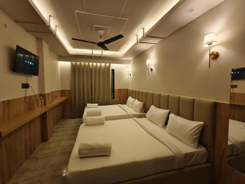 a bedroom with two beds and a ceiling fan at Hotel hk haridwar By hk guest house in Haridwār
