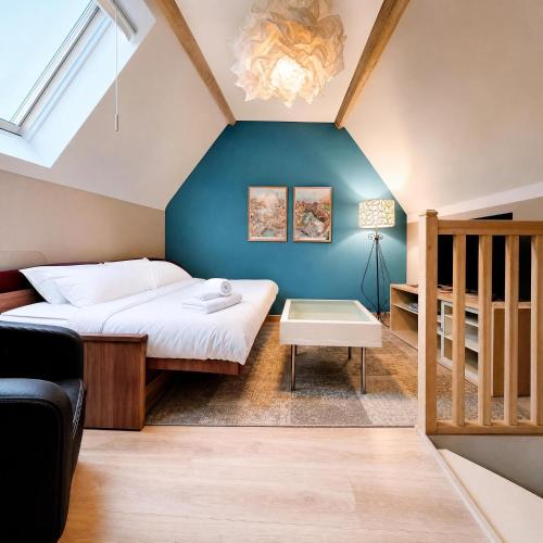a bedroom with a bed and a blue wall at Chez Maméta - Bail Partner in Auxerre
