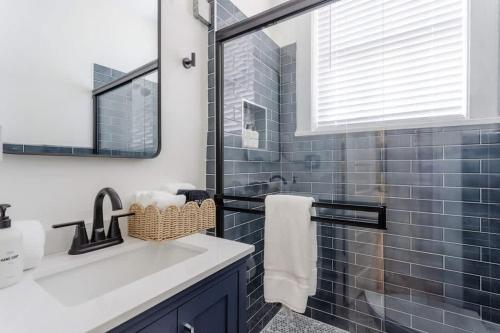 a bathroom with a sink and a glass shower at Chic Studio Apartment on Oglethorpe Square in Savannah