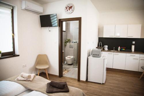 a white kitchen with a sink and a refrigerator at Öreg Fűz Apartman in Mosonmagyaróvár
