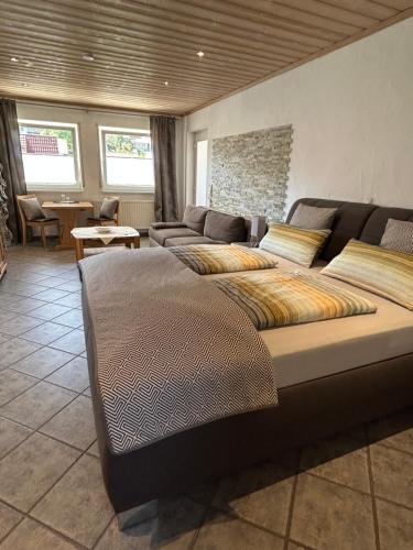 a living room with a large bed and a couch at Gästehaus Ingrid in Ramsthal